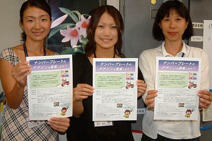 ちらしを手にオリジナルナンバープレートのデザイン応募を呼びかける担当職員
