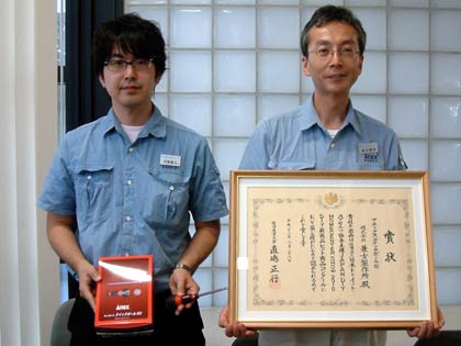 アネックス・クイックボール60ラチェットドライバーと経済産業大臣賞の賞状を手に兼古製作所の営業部企画課・羽賀貴広主任(左)と兼古義明専務(右)