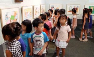 燕保育園園児によるテープカットで9月19日までの燕市立図書館「長谷川義史 絵本原画展」開幕