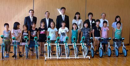 寄付した一輪車を前にみんなで記念撮影