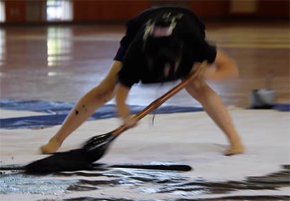 巨大な筆は体全体を使って動かす