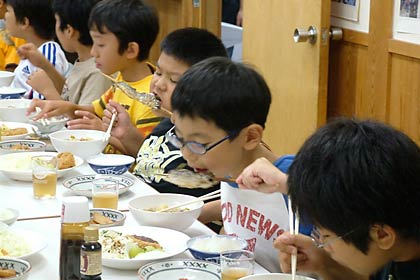 「コシヒカリ収穫体験in三条」で三条市を訪れている東京都・荒川区立第二峡田小学校の児童、「よってげ邸」で豪快にアユの塩焼きにかぶりつく