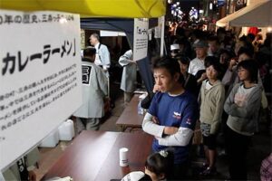 25日夜の本寺小路あかり物語第六章は、カレーラーメンなどの無料サービスに行列のにぎわい