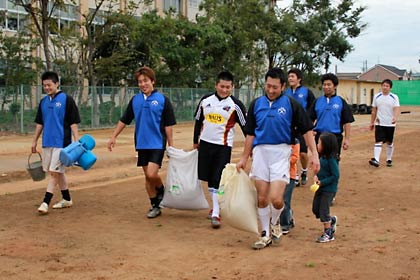 試合後は芝の種と炭粉をグラウンドに運んでまいた