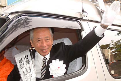 街宣車から笑顔で手を振る山井氏