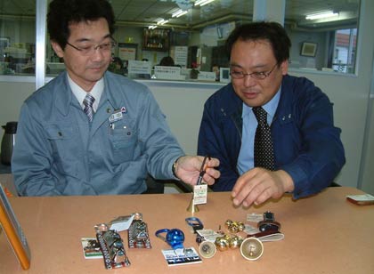 グリーンライフで扱うクマよけの鈴を説明する担当者