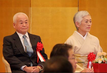緊張してステージで席を並べる玉川さん夫妻
