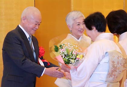 友人から花束と記念品を受け取る 