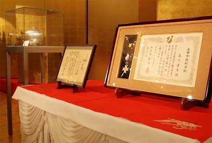 ステージに飾った左から燕市が購入した玉川さん作の木目金の花瓶、重要無形文化財保持者の認定書、燕市の名誉市民称号記