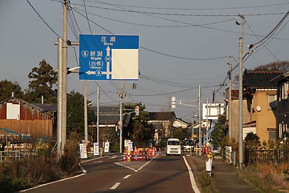 左岸側の県道141号白根黒埼線との交差点で行われている道路標識の設置作業