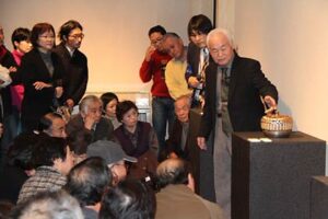 玉川宣夫金工展の作品解説会に約100人が参加し、目を輝かせて玉川さんの言葉に聞き入る