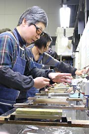 一心不乱に集中して包丁の刃を研ぐ