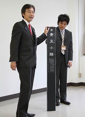 14日の定例記者会見で小路看板を紹介する国定三条市長