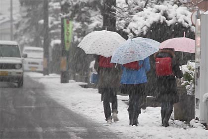 本成寺付近で雪のなか学校から帰る小学生