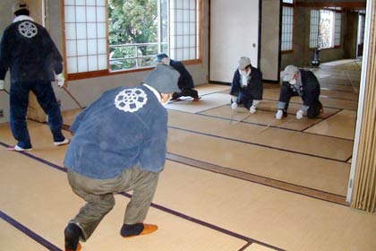 タケの棒で畳をたたいてほこりをたたき出す門前信徒