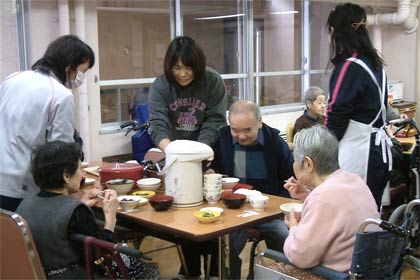 さっそく角利産業社長から寄付してもらったもちを味わう入所者