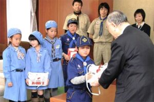 小池加茂市長に募金箱に入った善意を託すボーイスカウト加茂第1団とガールスカウト新潟県第30団