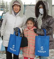 広報グッズを受け取った市民もにっこり