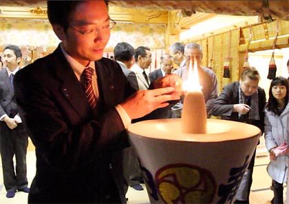 皮切りに「三条市長」とあるろうそくに点火する国定市長