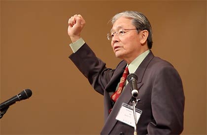 じぶしを突き上げて声高らかに決意表明する田中理事長