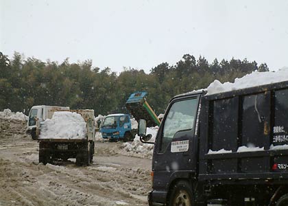 次々と雪捨場を訪れる雪を満載したダンプやトラック