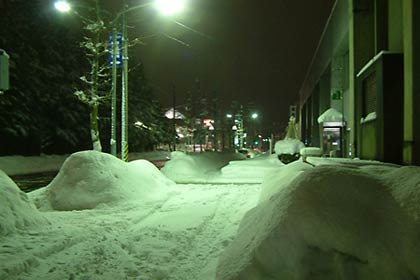 三条市役所前の歩道の水銀灯に照らされた雪の山