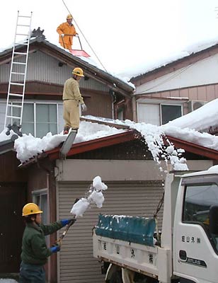 31日に三条市上須頃地内の住宅の雪下ろしをする外山組