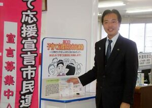第一号の子育て応援宣言を記入、投かんする国定市長