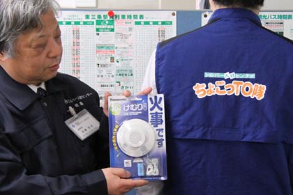 三条市シルバー人材センターの「ちょこっto隊」が火災警報器の取り付け事業で設置する火災警報機器と「ちょこっto隊」グループリーダー用のベスト