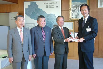 栄地区総合体育館に設置してもらうAED1台の目録を国定三条市長に手渡す栄ライオンズクラブの会員、左から木菱前会長、渡辺第一副会長、片野会長、市長