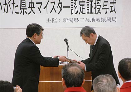 第5回にいがた県央マイスター認定証授与式で笠原三条地域振興局長から新たににいがた県央マイスター認定した高橋千春さんに認定証を手渡す