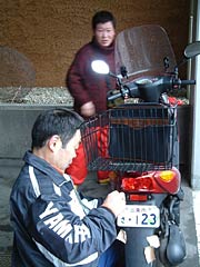 =さっそく市役所で新しナンバーに交換する女性