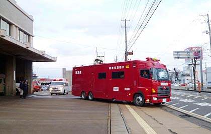 緊急消防援助隊としてまさに三条市消防本部を出発する支援車と高規格救急車