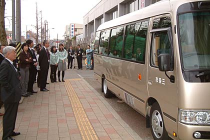 市役所を出発するマイクロバス