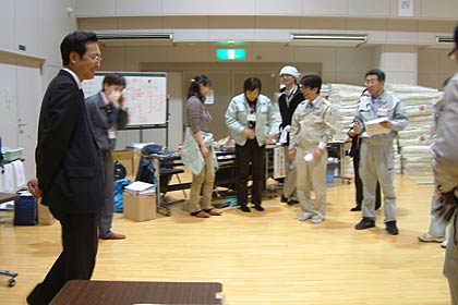 三条市総合福祉センターで福島県南相馬市からの団体避難者の到着前に職員と打ち合わせる国定市長