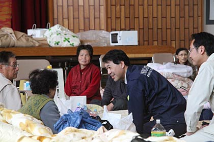 三条市総合福祉センターで避難所生活を始めた福島県南相馬市の市民と話す泉田知事、その後ろは国定三条市長