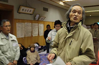 避難する市民の要望を伝える“村長”の佐藤さん(左)