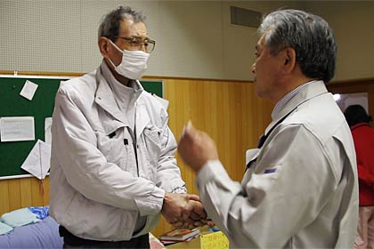 目を潤ませ、声を震わせて鈴木原町区役所長に握手を求める男性