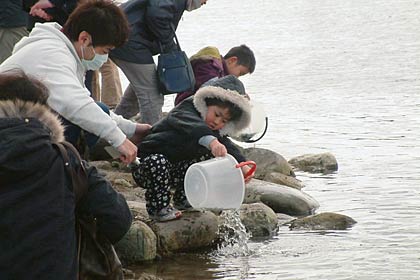 27日、五十嵐川の渡瀬橋上流右岸で行われたサケ放流イベント