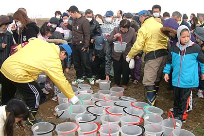 稚魚を入ったバケツを手に川端へ