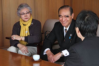 鈴木燕市長に寄付を手渡して歓談する東新の田中正信社長と専務で妻の登美枝さん
