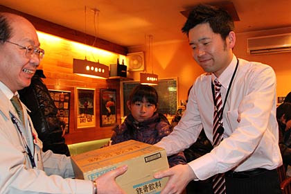 燕市職員に清涼飲料水などを手渡す自遊空間燕三条店の氏田店主