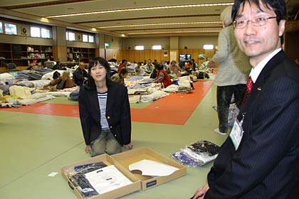 避難所で鈴木市長から制服を手渡す