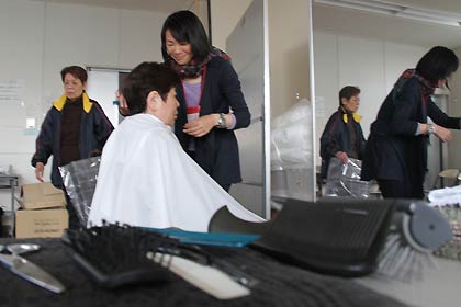 長テーブルにブラシやはさみを並べてヘアカット