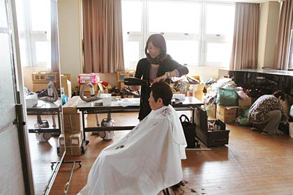 救援物資の置き場になっている音楽室が即席の美容室に