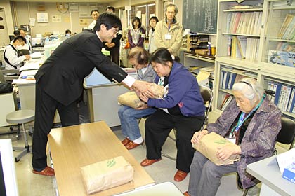燕市が第2避難所を開設している研修館・武道館で帰宅する3人に鈴木市長から燕産のコメ10kg