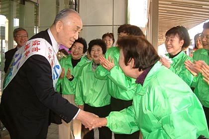 選挙事務所へ戻って運動員と握手する小池氏