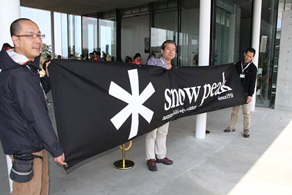 「snow peak headquarters」がグランドオープン、横断幕を掲げて来場者を迎える。