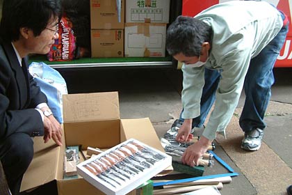 三条市の金物業者から寄付を受けた大工道具を広げて鈴木市長に見せる谷地正記さん