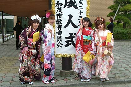 成人式の立て看板の前で振り袖の新成人たち